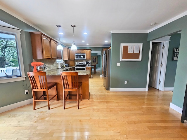 kitchen featuring a peninsula, stainless steel appliances, crown molding, backsplash, and baseboards