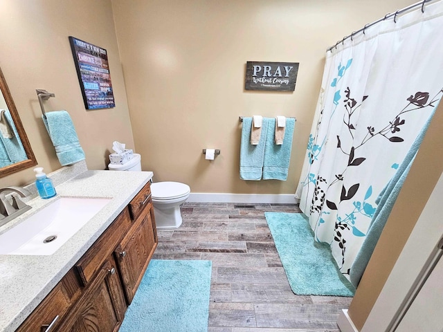 full bath featuring toilet, wood finished floors, vanity, a shower with shower curtain, and baseboards