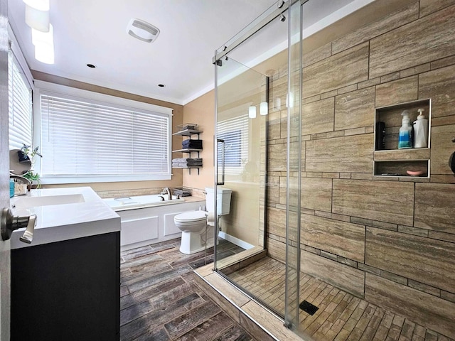 bathroom with vanity, wood finished floors, toilet, a bath, and a stall shower