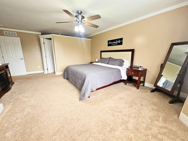 carpeted bedroom with a wood stove, visible vents, crown molding, a ceiling fan, and baseboards