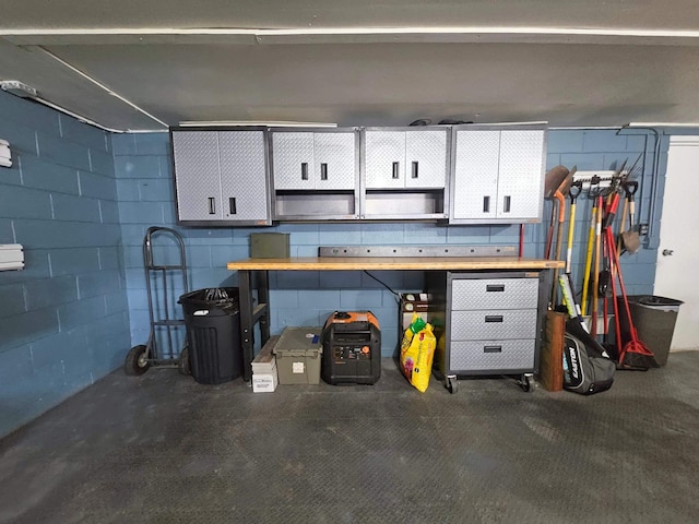 garage with concrete block wall and a workshop area