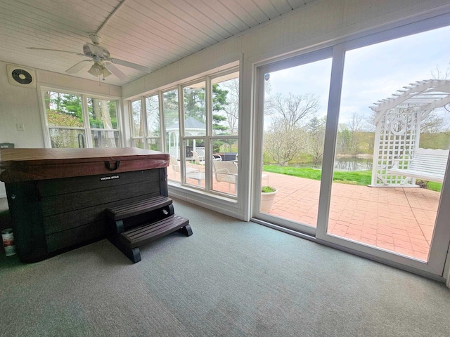 sunroom featuring a water view, ceiling fan, and carpet floors