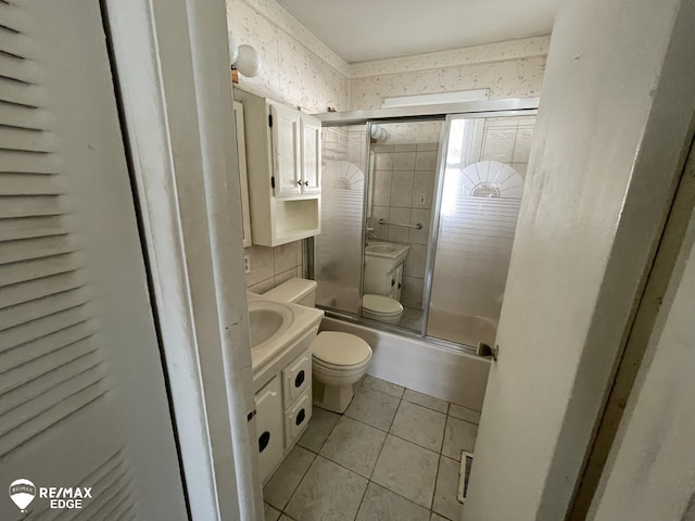 full bath with tile patterned flooring, visible vents, vanity, toilet, and a tile shower