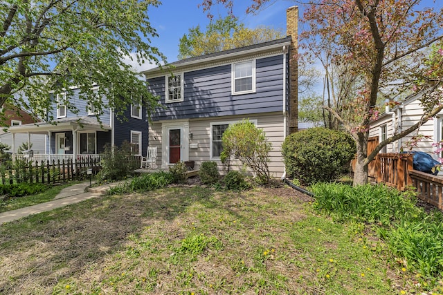 view of front of house featuring fence and a chimney