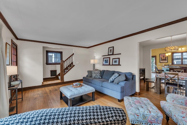 living room featuring baseboards, ornamental molding, stairway, and hardwood / wood-style floors