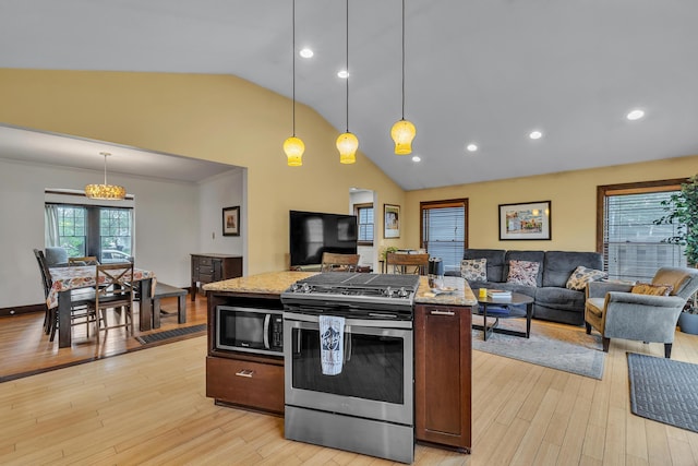 kitchen featuring stainless steel range with gas stovetop, open floor plan, and plenty of natural light