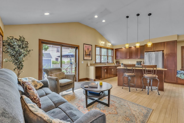 living room with recessed lighting, high vaulted ceiling, and light wood-type flooring