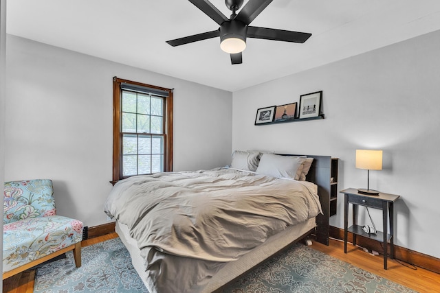 bedroom with baseboards, ceiling fan, and wood finished floors