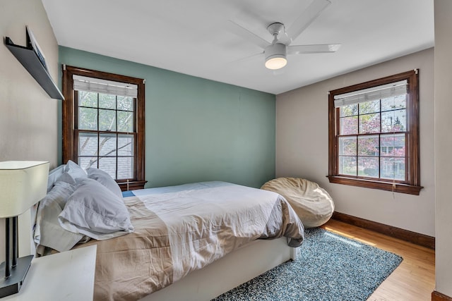 bedroom featuring baseboards, ceiling fan, and wood finished floors