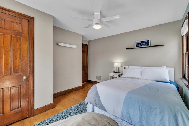 bedroom with baseboards, ceiling fan, light wood-style flooring, and visible vents