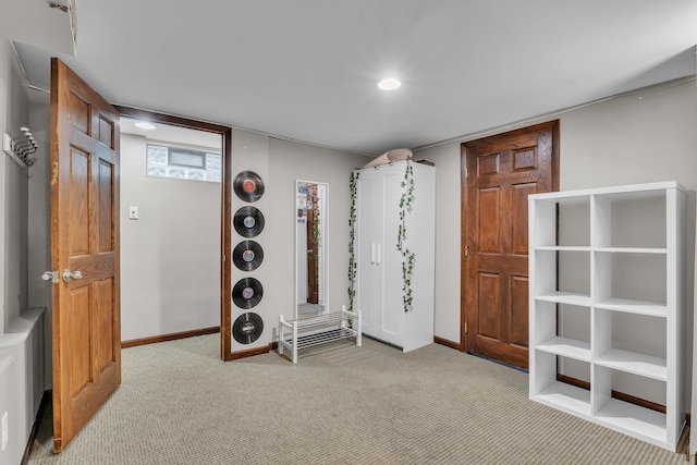 interior space featuring baseboards and light colored carpet