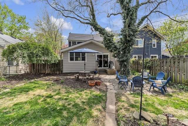 rear view of property with a patio, a fenced backyard, and a yard