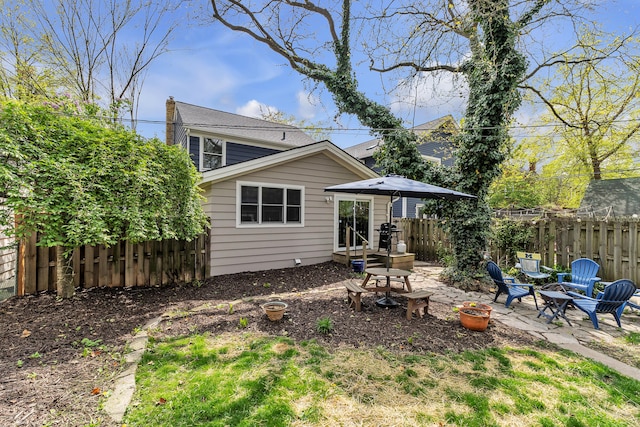 rear view of house featuring fence, a fire pit, and a patio area