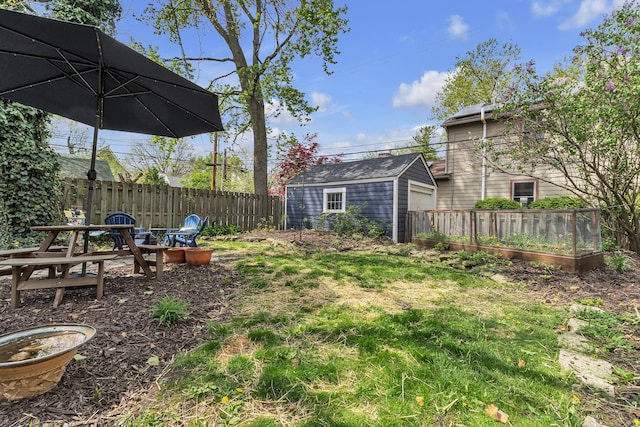 view of yard featuring an outdoor structure, a garage, and fence
