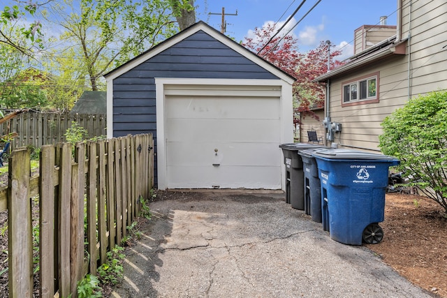 detached garage with aphalt driveway and fence