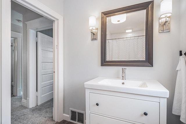 bathroom featuring visible vents, baseboards, and vanity