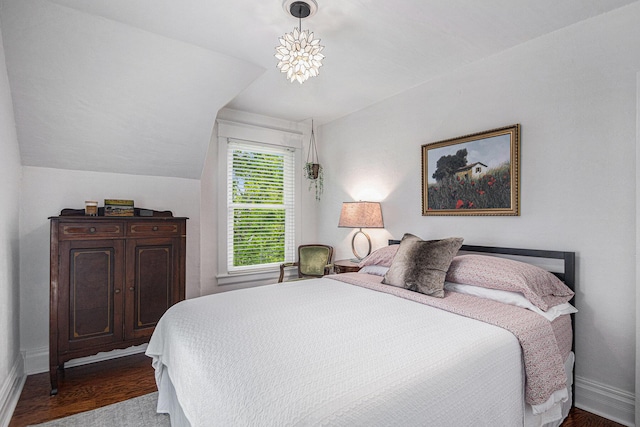 bedroom featuring baseboards, vaulted ceiling, and wood finished floors