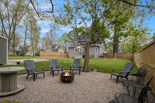 exterior space featuring a fenced backyard, a fire pit, and a residential view