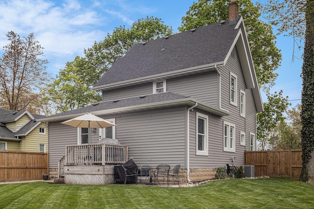 rear view of property with a lawn, a fenced backyard, a chimney, and a deck