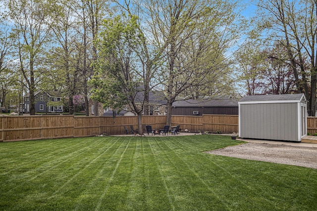 view of yard featuring an outbuilding, a patio area, fence, and a storage shed