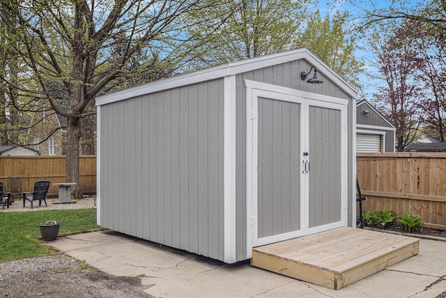 view of shed with a fenced backyard and an outdoor fire pit