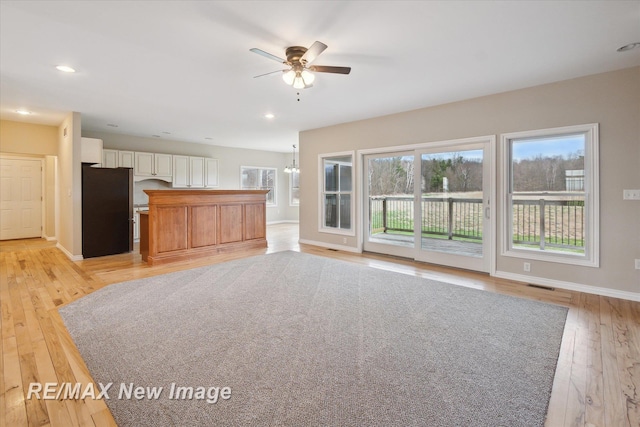 unfurnished living room with light wood-style flooring, a ceiling fan, baseboards, recessed lighting, and visible vents