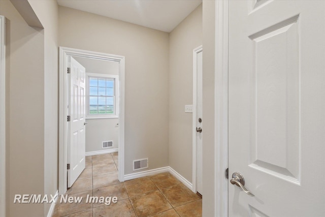 laundry room with visible vents, baseboards, and light tile patterned floors