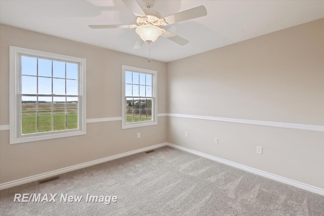 spare room with carpet flooring, baseboards, visible vents, and ceiling fan
