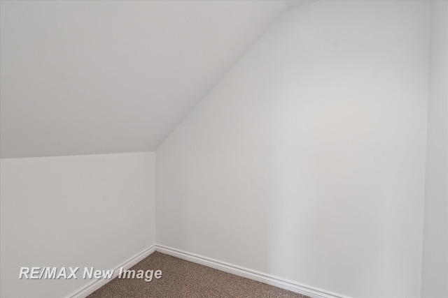 bonus room with baseboards, carpet flooring, and vaulted ceiling