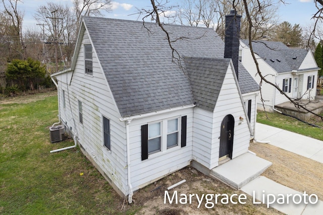 224 N Hewitt Rd, Ypsilanti, MI 48197 - view of front of house featuring a shingled roof, cooling unit, a front lawn, and a chimney