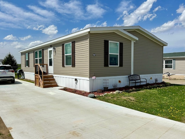 manufactured / mobile home with driveway and a front yard