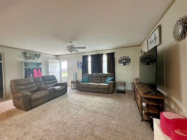 living room with crown molding, carpet floors, and ceiling fan