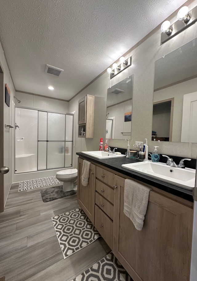 full bathroom featuring visible vents, a sink, wood finished floors, and toilet
