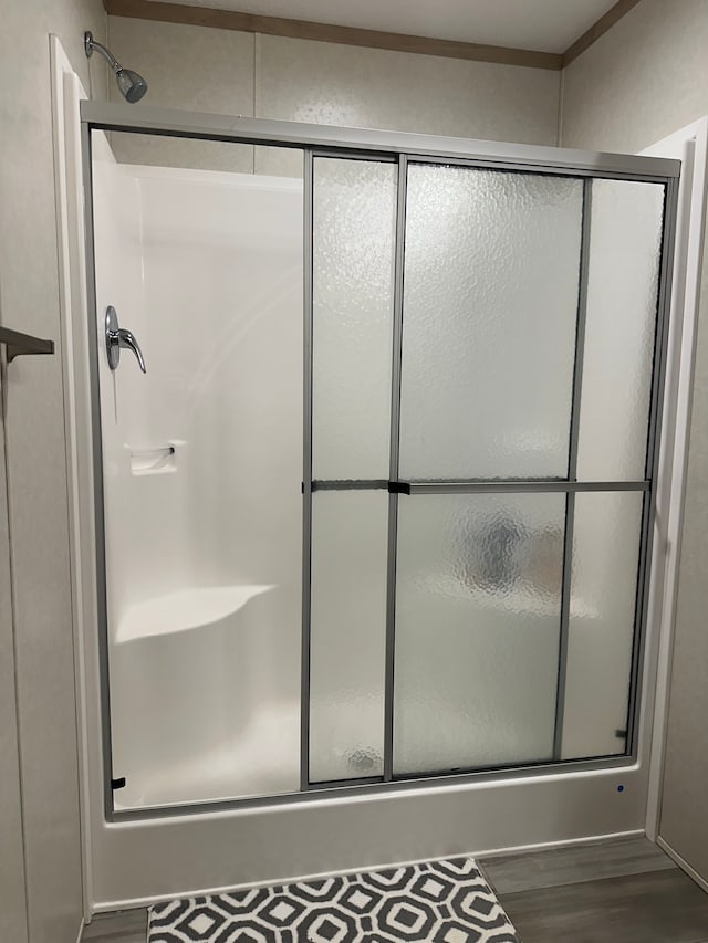 full bath featuring a shower stall and wood finished floors