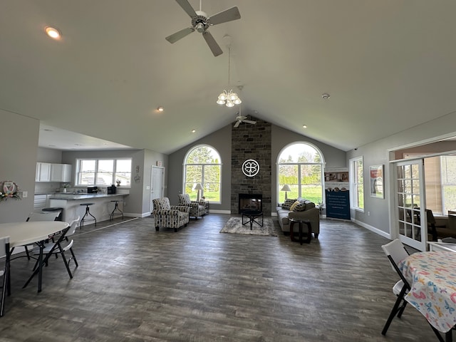 living room with dark wood-style flooring, a fireplace, a ceiling fan, baseboards, and vaulted ceiling