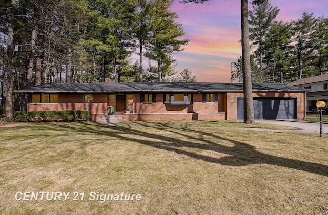 ranch-style house with driveway, a chimney, a lawn, a garage, and brick siding