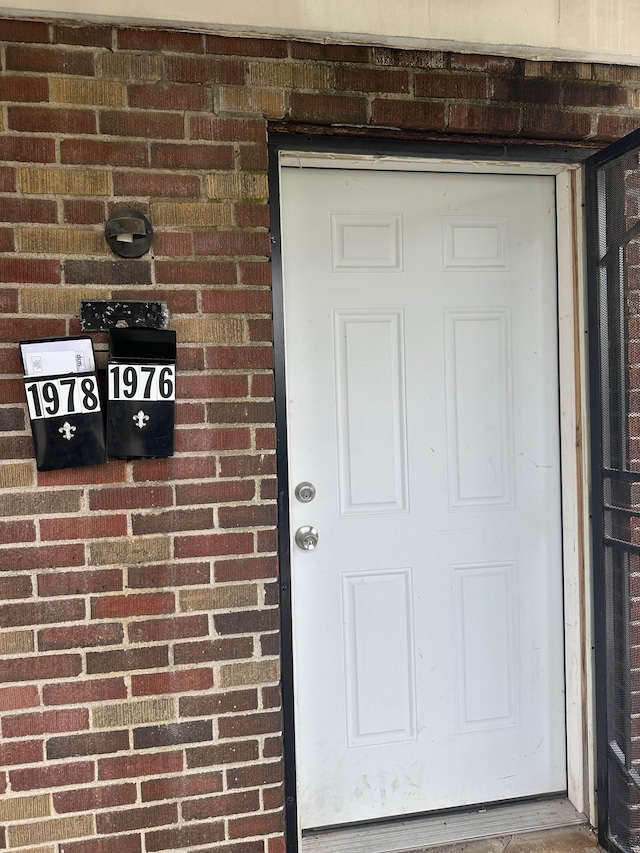 doorway to property with brick siding