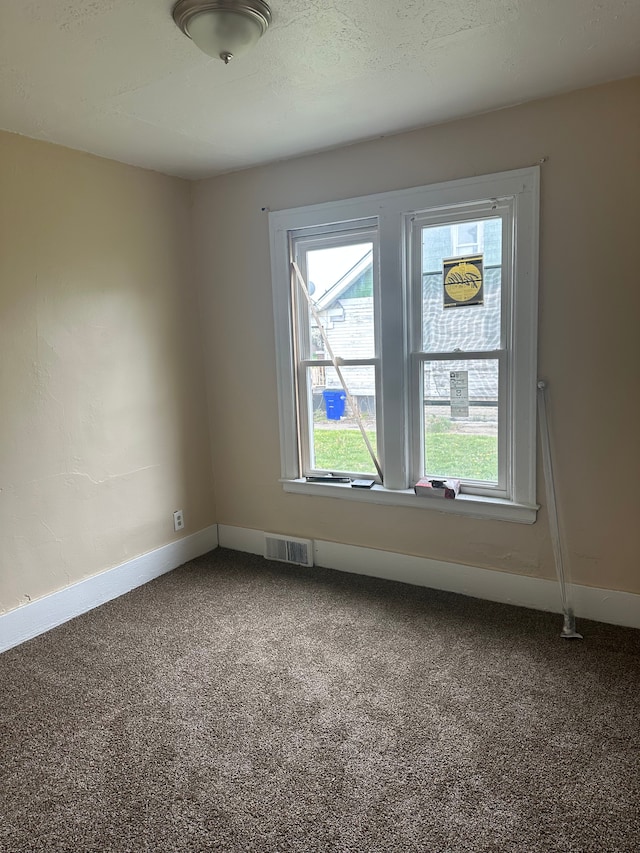 unfurnished room featuring visible vents, carpet flooring, and baseboards