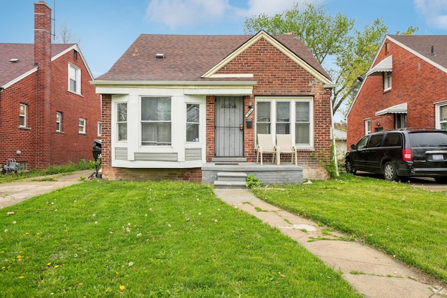 14141 Edmore Dr, Detroit, MI 48205 - bungalow-style house featuring roof with shingles, a front lawn, and brick siding