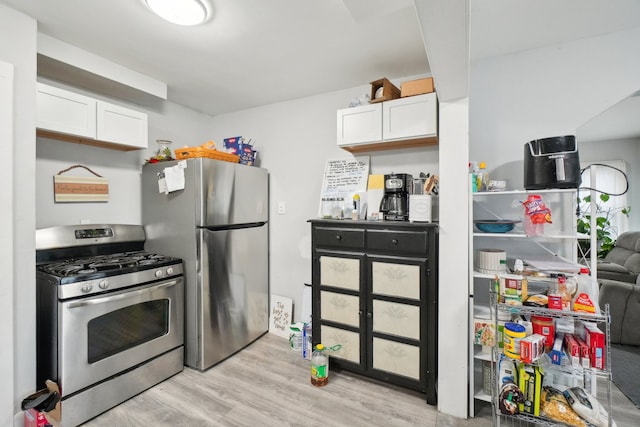 14141 Edmore Dr, Detroit, MI 48205 - kitchen with light wood-type flooring, appliances with stainless steel finishes, and white cabinetry