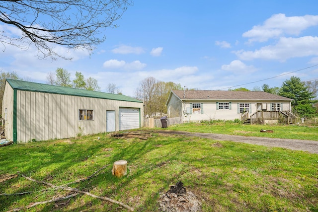 view of front of property featuring a garage, an outbuilding, driveway, and a front lawn