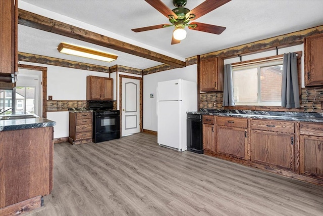 7960 Jackson St, Taylor, MI 48180 - kitchen featuring a sink, black gas range oven, freestanding refrigerator, light wood-type flooring, and beamed ceiling