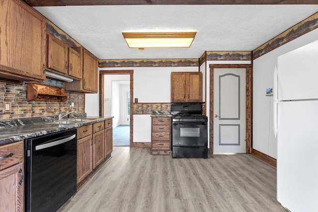 7960 Jackson St, Taylor, MI 48180 - kitchen featuring light wood finished floors, brown cabinets, a sink, dark countertops, and black appliances