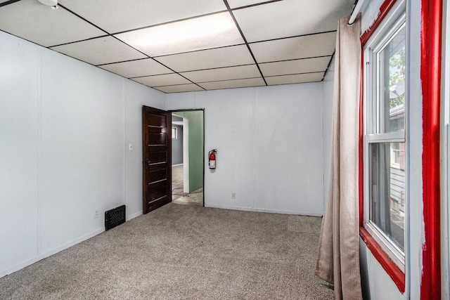 carpeted spare room featuring visible vents and a paneled ceiling