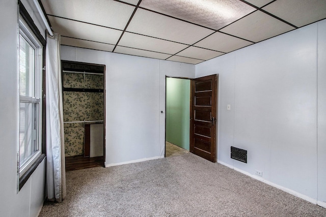 spare room with baseboards, carpet, visible vents, and a paneled ceiling