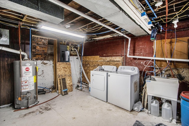 unfinished below grade area with a sink, gas water heater, and independent washer and dryer