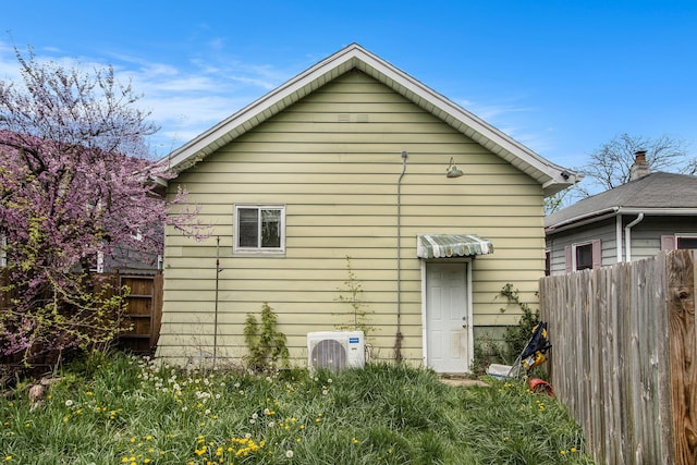 back of house with ac unit and fence