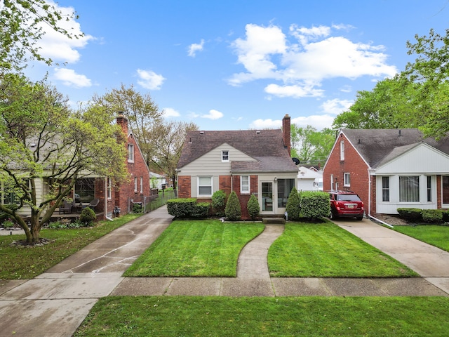 bungalow-style home featuring brick siding, concrete driveway, a front yard, and a chimney