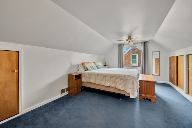 bedroom featuring baseboards, lofted ceiling, dark colored carpet, and visible vents