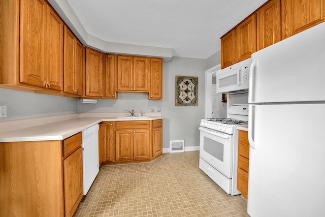 kitchen with a sink, brown cabinetry, white appliances, and visible vents